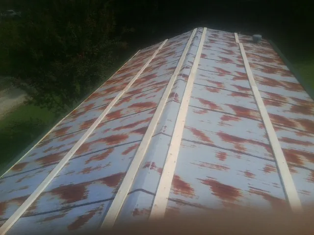 Rusted metal roof panels with new wood purlins before replacement — Storm Damage Roof Repair in Odenville by Roofing Brothers