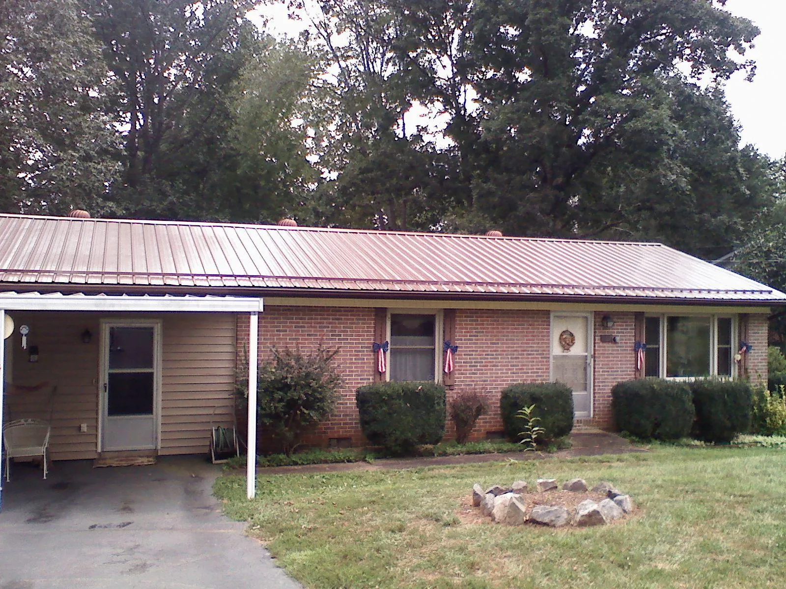 Bronze metal roof and carport on a brick ranch home — Roof Repair work by our crew in Odenville