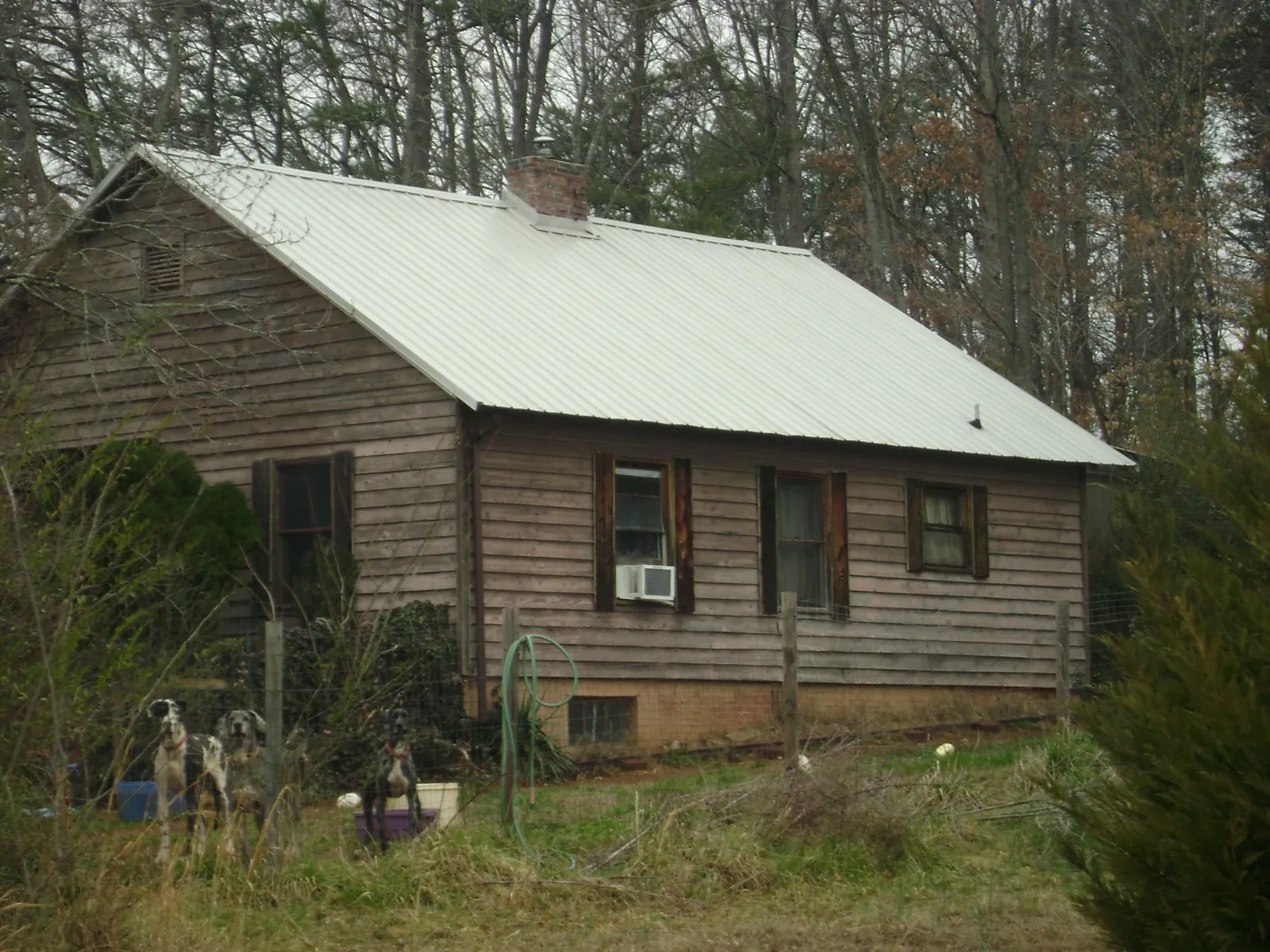 White metal roof on an old wood sided farmhouse, from a Metal Roof Installation job in Odenville